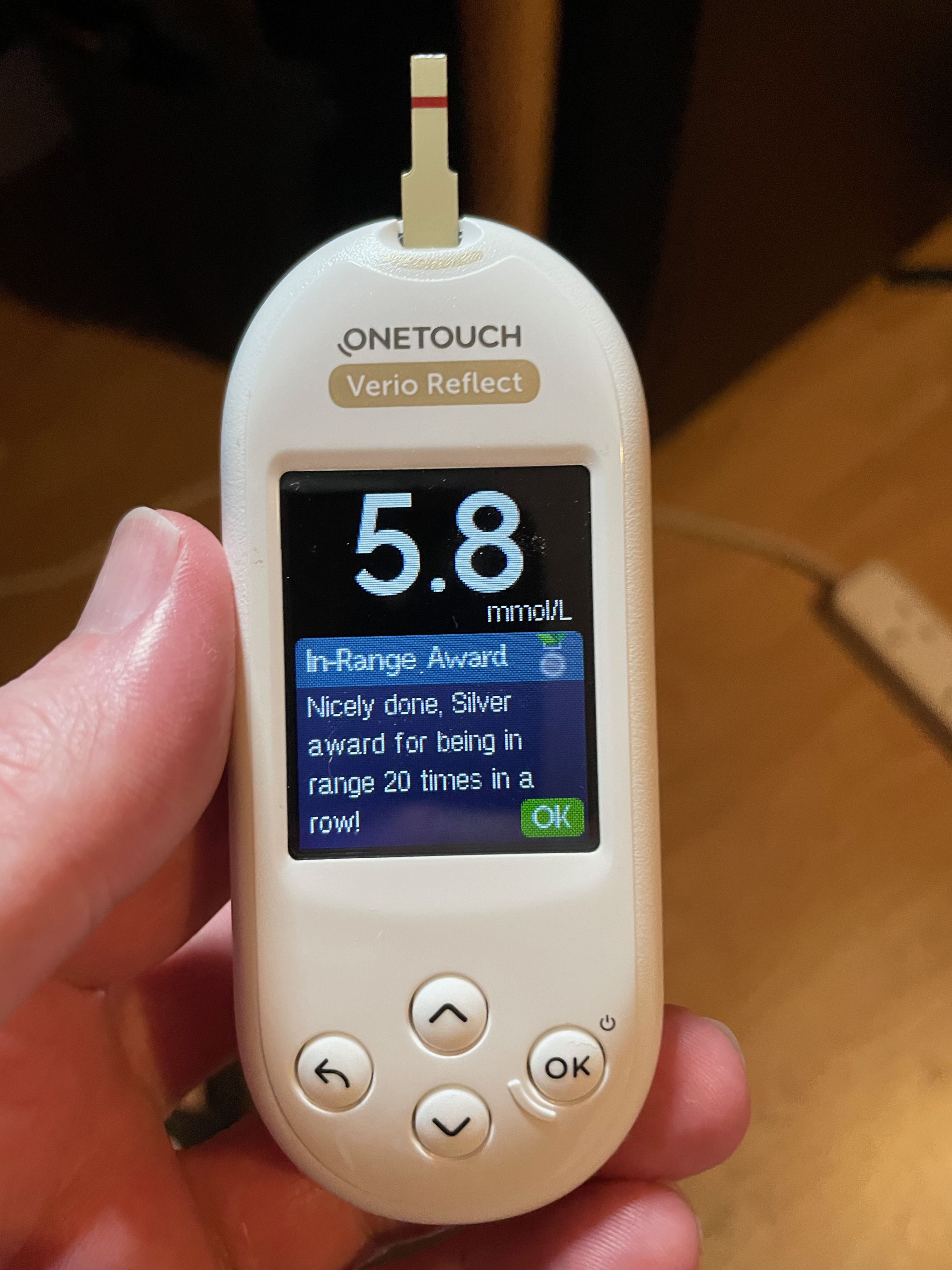 My blood glucose meter showing a reading of 5.8 mmol/L and an icon of a silver medal because I got 20 in-range readings in a row.